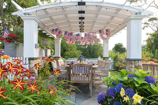 Festive Fourth of July party table set under garden pergola in Chatham, Massachusetts, United States
