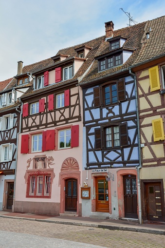 Colmar, France – June 23, 2022: A vertical shot of a street in Colmar, Alsace with typical colorful houses in France