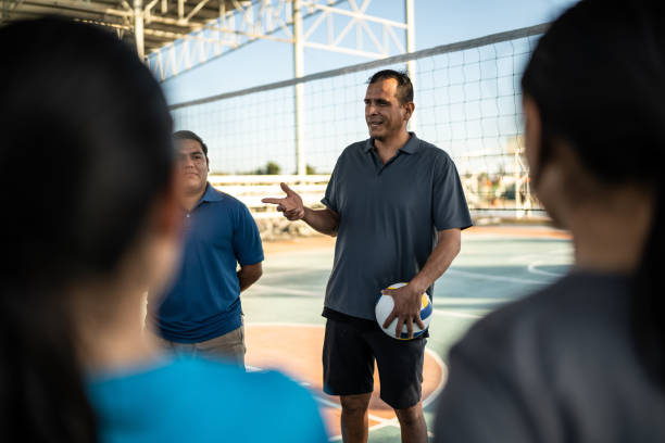 istock Coaches ( or sports judge ) talking with the volleyball players before the game 1454026350