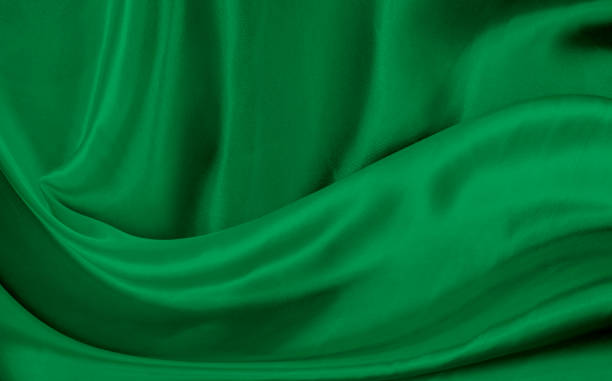 istock Black green satin dark fabric texture luxurious shiny that is abstract silk cloth background with patterns soft waves blur beautiful. 1454026476
