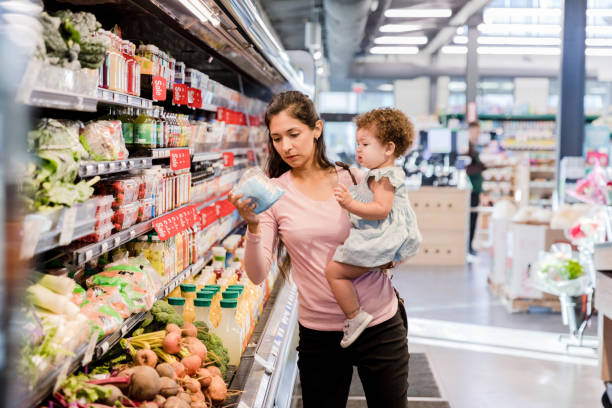 Mãe jovem fazendo compras de supermercado - foto de acervo