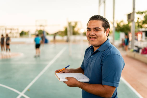 portrait d’un jeune entraîneur tenant un bloc-notes sur un terrain de sport - éducation physique photos et images de collection