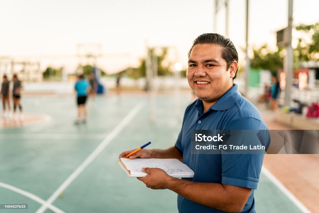 Portrait of young coach man holding a note pad at sports court Coach Stock Photo