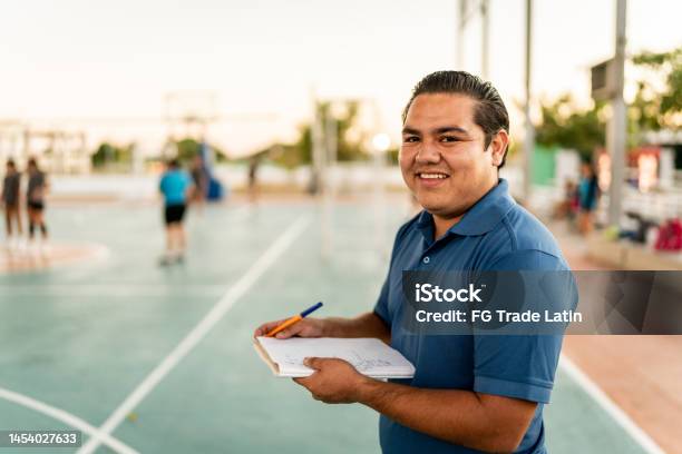 Portrait Of Young Coach Man Holding A Note Pad At Sports Court Stock Photo - Download Image Now