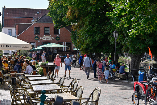 Greetsiel, Germany, September 4, 2022 - Tourists and locals sit in the restaurants and café at the market in Greetsiel on the East Frisian North Sea coast.