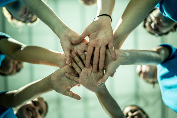 Sports female team stacking hands on a inspirational speech