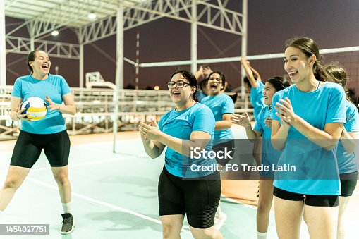 istock Female volleyball talking after finish of training or celebrating victory after game at sports court 1454027751