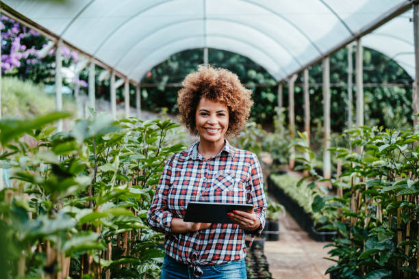 istock Woman checking crops in greenhouse using digital tablet 1454032906