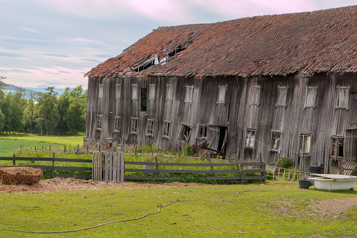 Dilapidated old wooden barn about to collapse. Seen on the St. Olavsweg, Gudbrandsdalsleden near Hamar . The pilgrim path runs from Oslo to Trondheim