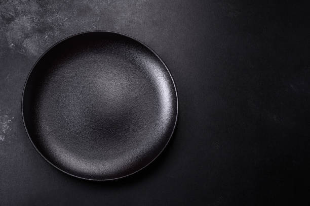 istock Empty beautiful black ceramic plate on a dark concrete background 1454037881