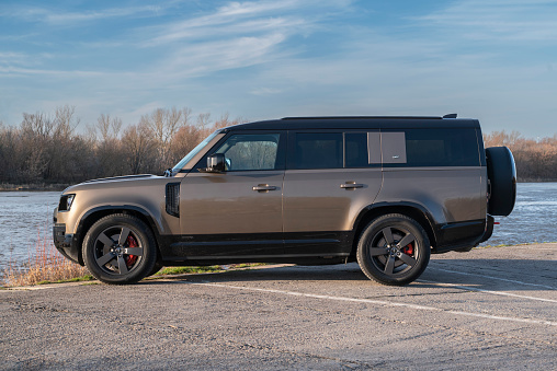 Tulsa, Oklahoma, USA  - December 12, 2011: Side view of a black 1992 Isuzu Trooper SUV with Cooper tires parked in a wooded area. Isuzu is a multinational car company headquartered in Japan.