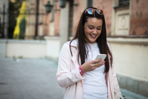 istock Stylish woman using smartphone outdoors in the city. 1454038641