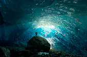 Man inside a glacial ice cave