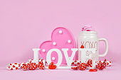 Cute Valentine's Day decoration with Love text sign, hearts, candy and cup
