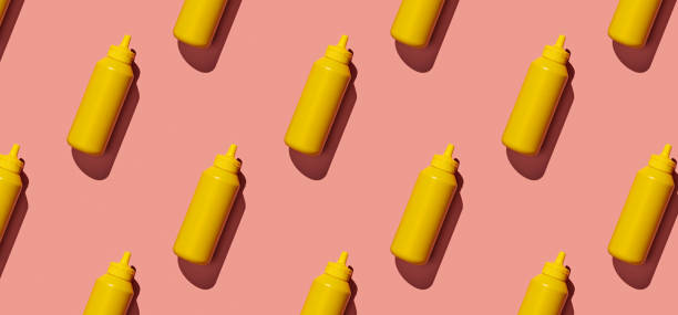 istock Pattern of mustard bottles on orange pastel background 1454044466