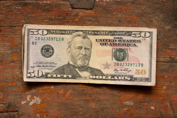 50 dollars lie on an old wooden table, financial theme
