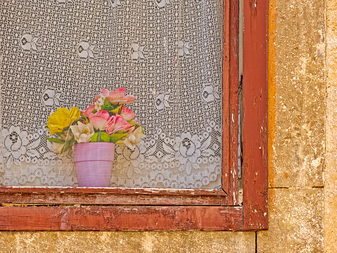 Vintage windowsill with flower boxes on a brick wall, showing signs of wear and rustic charm.