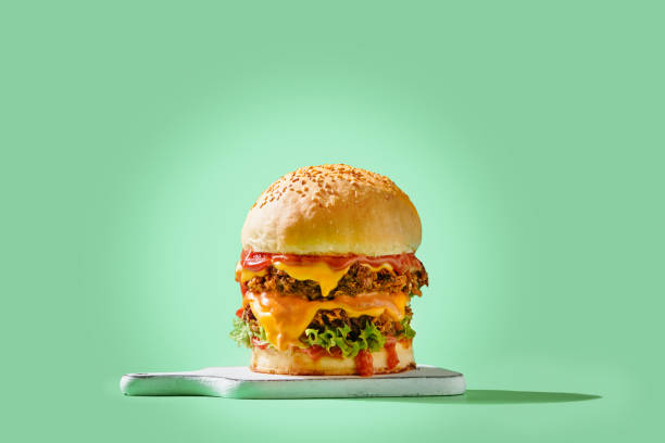 istock Fresh tasty burger on green background 1454046168