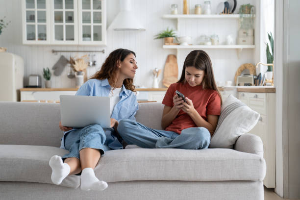 istock Curious parent mom peeping who kid chatting in social networks while spending time together at home 1454049343