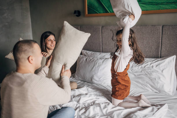 pelea de almohadas en la suite del hotel - bed couple pillow fight men fotografías e imágenes de stock