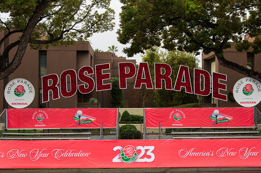 Pasadena, California, United States - December: sign including a floral composition announcing the famous Rose Parade shown on a rainy New Year's Eve.