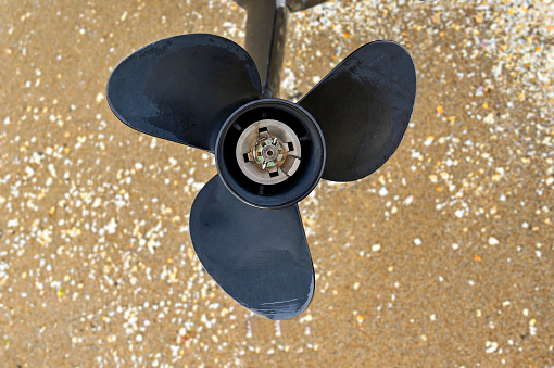 Close up view of the propeller of a small motorboat. No people.