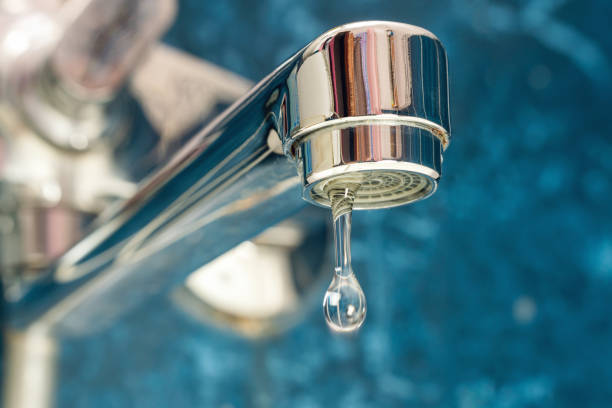 una goccia d'acqua gocciola da un rubinetto che perde - rubinetto foto e immagini stock