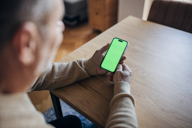 Blank green screen mobile phone in man's hand