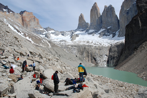 Torres Paine N.P, W Circuit, Chile - nov 9, 2006: a hiker rest and take photos in front of the granite and vertical walls of the Torres, in the Torres del Paine park