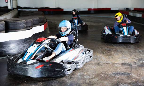 istock Group of people driving go-carts at racing track 1454060935