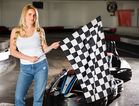 Portrait of girl holding finish flag at kart racing track