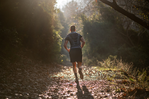 Outdoor cross-country running in morning sunrise for exercising, fitness and healthy lifestyle.