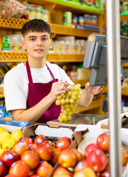 istock Guy seller weighs grapes on a scale 1454062247