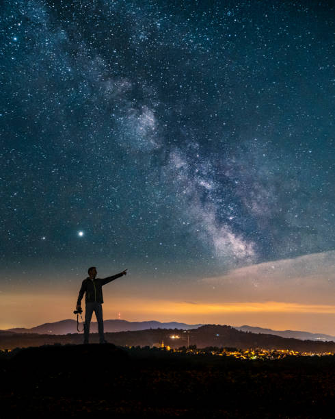 istock Vertical shot of man pointing in star sky 1454062398