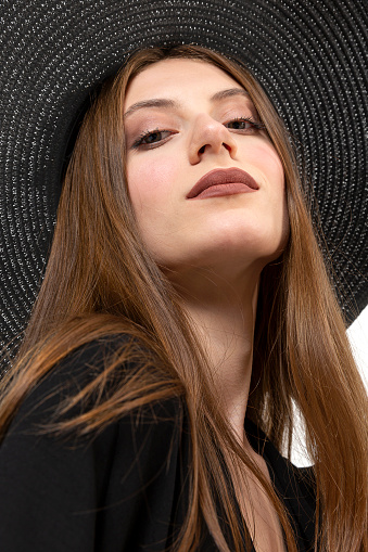 Close up portrait of a smiling woman with brown straw hat.