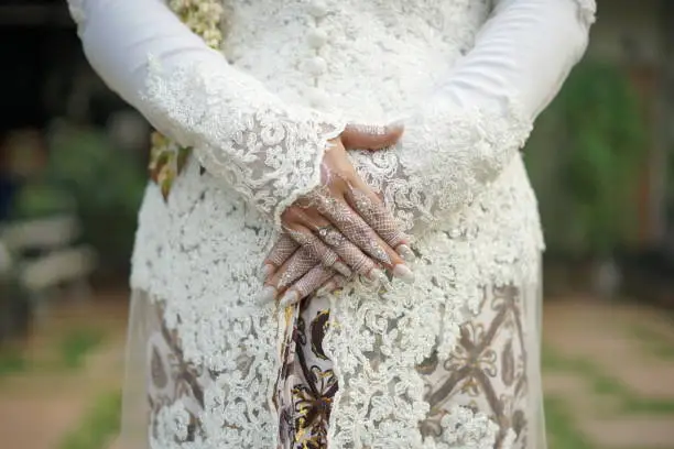 Photo of The bride wears a kebaya while holding her hand out and the ring attached to her ring finger.