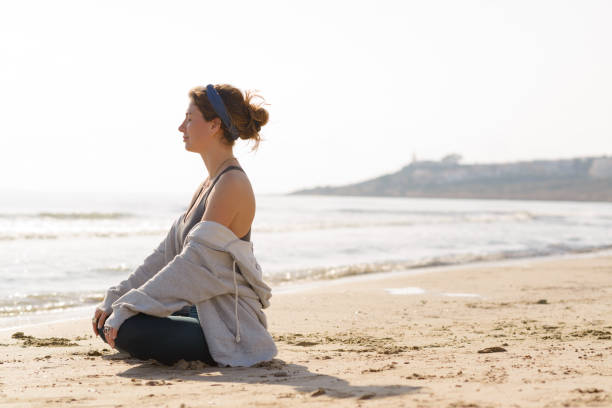 istock young woman does yoga on the beach 1454071058