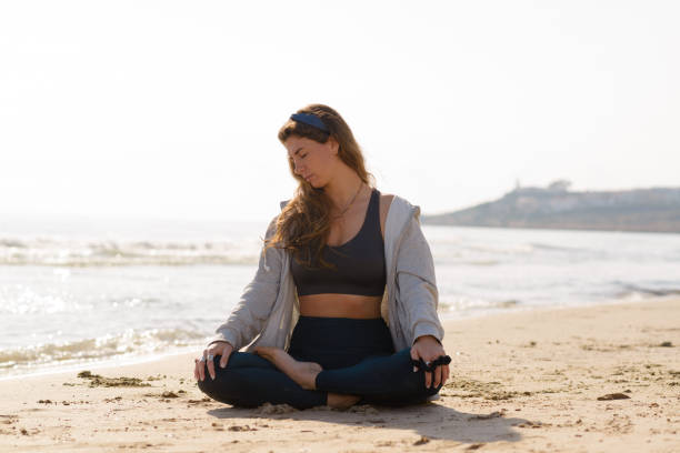 istock young woman does yoga on the beach 1454071061