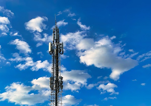 telecommunication tower on blue cloud scattered background