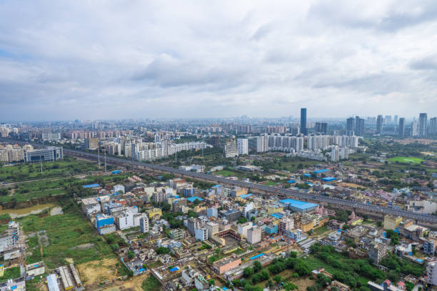 istock aerial drone shot over gurgaon showing monsoon clouds with light rays falling on ground crowded with homes houses, sohna highway feilds and water pools around under construction buildings 1454074347