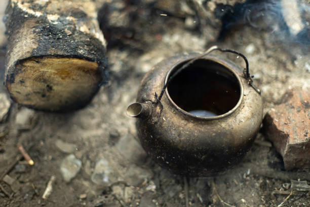 Kettle stands on coals. Kitchen in nature. Picnic details. Making tea.