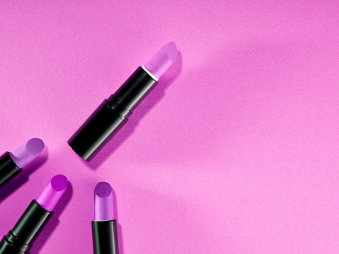 Lipstick and makeup on a pink background. Place for text