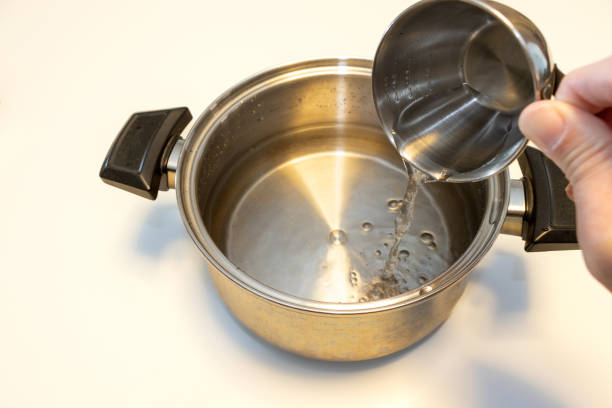 istock Pour water into the pot while measuring the amount with a cup 1454077716