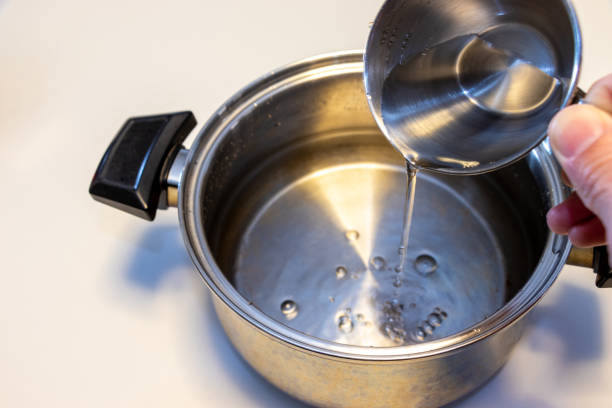 istock Pour water into the pot with a cup 1454077719