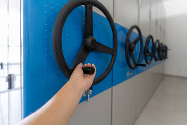 A hand that rotates the steering wheel of the filing cabinet