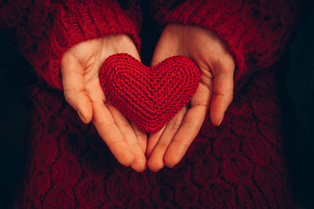 istock Female hand holding red knitted heart 1454079989
