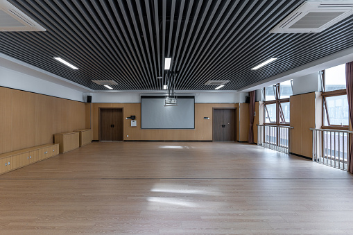 Projection screen and wooden floor of empty dance classroom