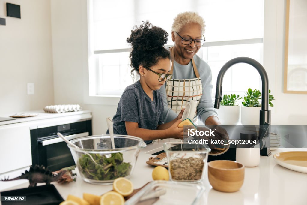 Family friendly Caribbean vacation rentals Grandmother and grandkids cooking together in the kitchen Family Stock Photo Family friendly Caribbean vacation rentals Grandmother and grandkids cooking together in the kitchen Family Stock Photo