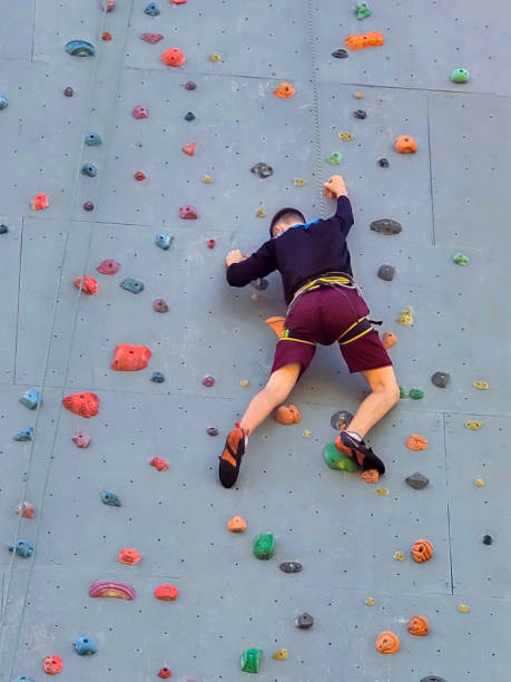 Boy at the climbing wall without a helmet, danger at the climbing wall.