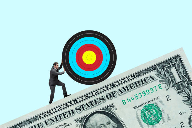 istock Man Pushing Target Up Slope Created By One Dollar Bill 1454089445